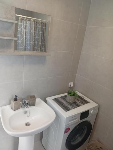 a bathroom with a sink and a washing machine at Markos House 2 in Kalymnos