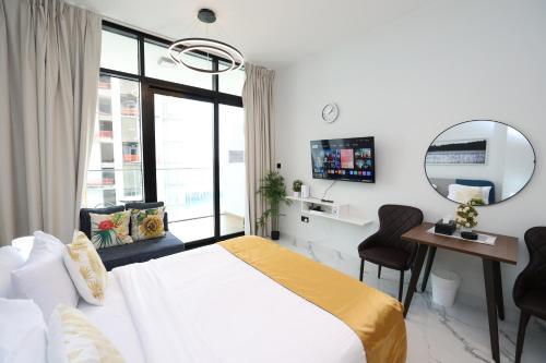 a bedroom with a bed and a desk and a mirror at Central Stay Studio Apartment near Cleveland and Abu Dhabi Mall in Abu Dhabi
