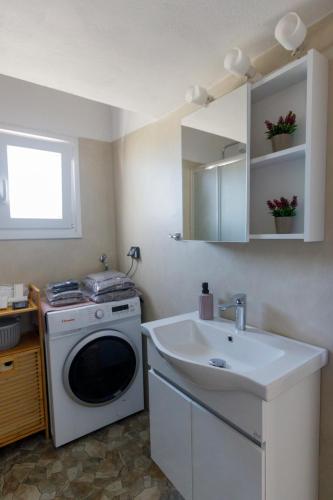 a kitchen with a washing machine and a sink at La casa nel campo in Syros Island National Airport