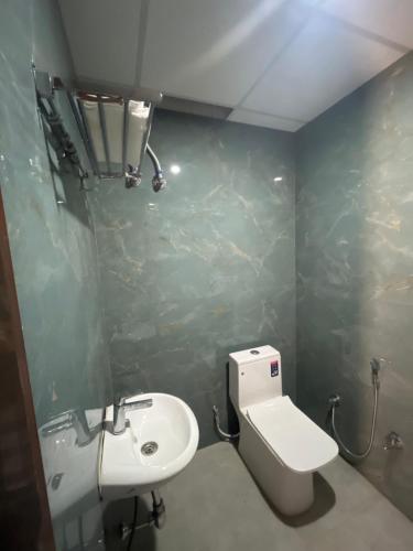 a bathroom with a white toilet and a sink at HOMESTAY KT palace in Varanasi