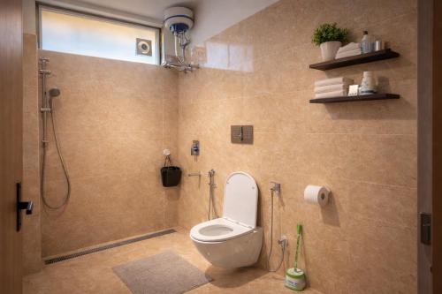 a bathroom with a toilet and a shower at Omaya Vista in Mukteshwar