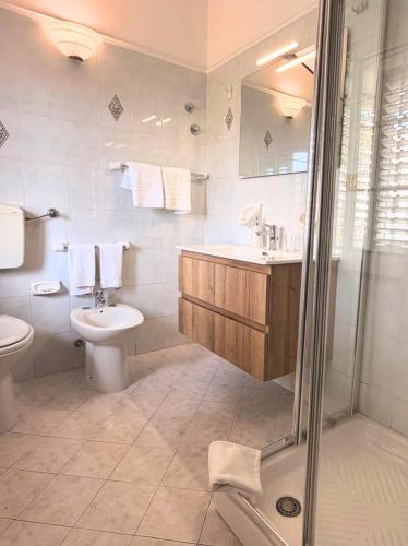 a bathroom with a toilet and a sink and a shower at Villa Ambra B&B in Noto