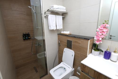 a bathroom with a shower and a toilet and a sink at Central Stay Studio Apartment near Cleveland and Abu Dhabi Mall in Abu Dhabi
