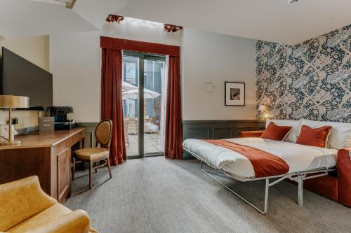 a hotel room with a bed and a desk and a kitchen at The Crown & Greyhound by Innkeeper's Collection in London