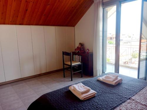 a bedroom with a bed with two towels on it at Family Booklovers space in Aigio