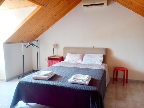 a bedroom with a bed with two towels on it at Family Booklovers space in Aigio