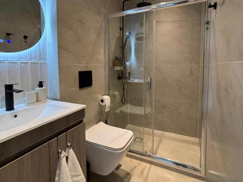 a bathroom with a shower and a toilet and a sink at Covea by the Sea Boho Seaside Apartment, 400 m from the Beach in Perea
