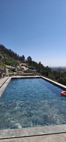 a large swimming pool with a view of the ocean at Gardunha Stone in Louriçal do Campo