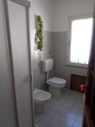 a bathroom with a toilet and a christmas tree at Casa vacanze sa minda noa whit a private garden in Olbia