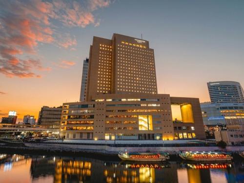 a large building in a city next to a river at Yokohama Sakuragicho Washington Hotel in Yokohama