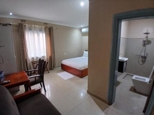 a hotel room with a bed and a bathroom at Gosen Hotel Lubumbashi in Lubumbashi