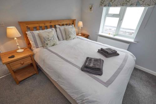 a bedroom with a large white bed with two towels on it at Naam Place in Lincoln