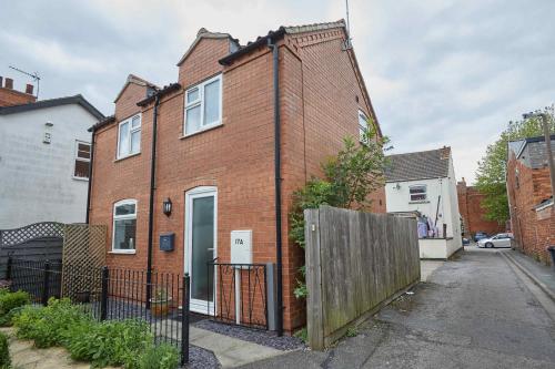 a brick house with a fence in front of it at Naam Place in Lincoln