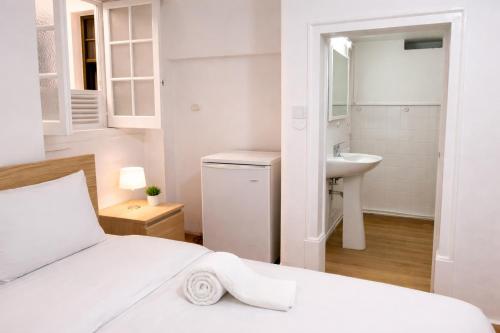a white bedroom with a bed and a sink at Relax Guesthouse & Hostel Lagos Central in Lagos