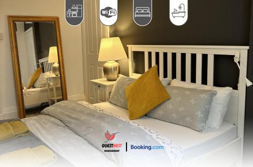 a bedroom with a bed with pillows and a mirror at 1 Bedroom Apartment By Guest Nest Management Vacation Rental Brighton - Pet-Friendly in Brighton & Hove