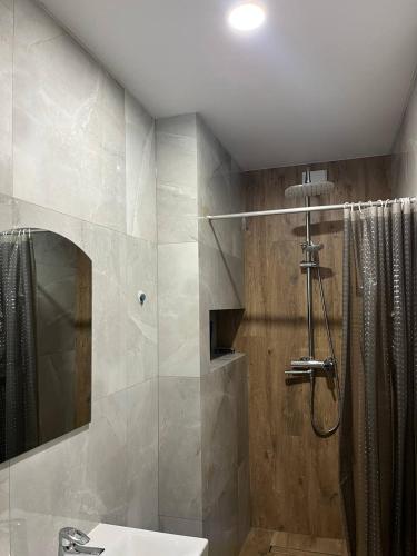 a bathroom with a shower and a sink and a mirror at Villa Maria in Slavske