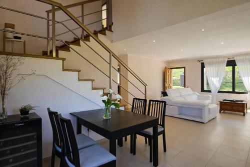 a living room with a dining table and a staircase at Casa en Llanes con jardín - Huergo Mar y Playa in Nueva de Llanes