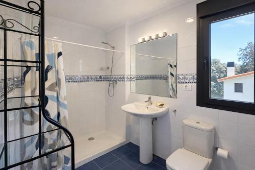 a bathroom with a sink and a toilet and a mirror at Casa en Llanes con jardín - Huergo Mar y Playa in Nueva de Llanes