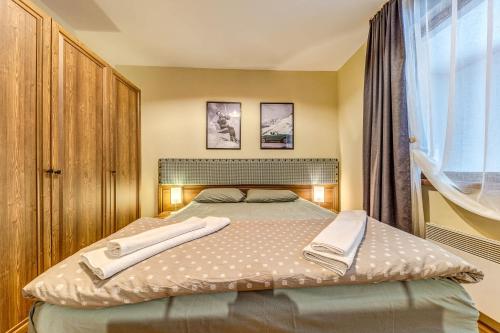 a bedroom with a bed with two towels on it at Ember Suite 1BR - Mountain Lake Complex By Flat Mаnager in Smolyan