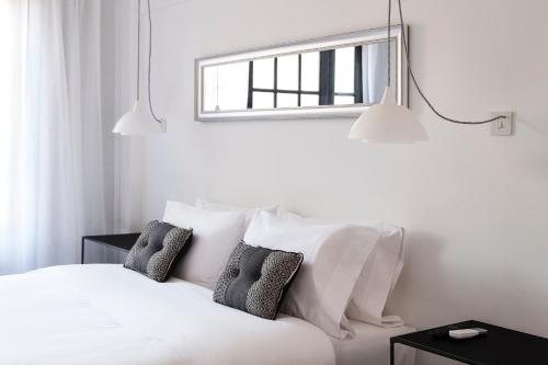a bedroom with a white bed with pillows and a window at Hotel Alto San Isidro in San Isidro