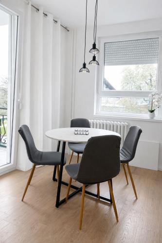 ein Esszimmer mit einem Tisch und vier Stühlen in der Unterkunft NeraHome in Banja Luka