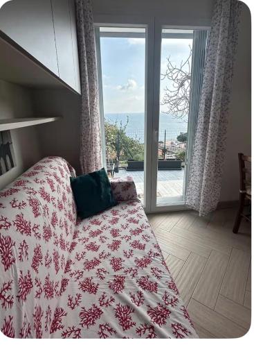 a bedroom with a bed and a view of the ocean at Casa del sasso in Bergeggi