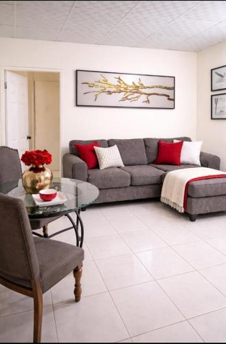 a living room with a couch and a table at PINK POUI Spaces Vacation Rentals in Arima