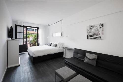 a black and white bedroom with a bed and a couch at Hotel Alto San Isidro in San Isidro