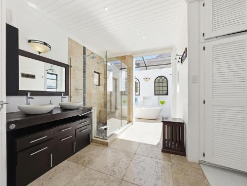a bathroom with two sinks and a walk in shower at The Coastal Crown in Ballito