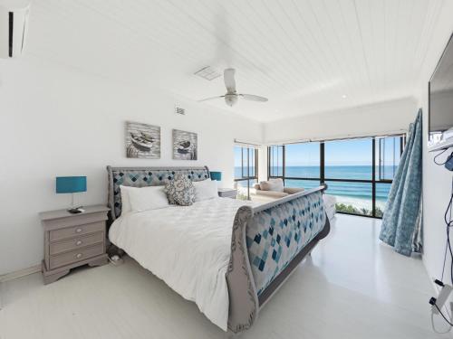 a bedroom with a bed with a view of the ocean at The Coastal Crown in Ballito