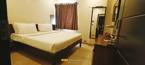 a hotel room with a bed and a mirror at Theni hotel ramyas in Theni