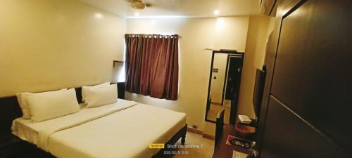 a hotel room with a bed and a window at Theni hotel ramyas in Theni