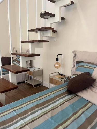 a bedroom with a bed and a spiral staircase at Cavour Apartment in LʼAquila