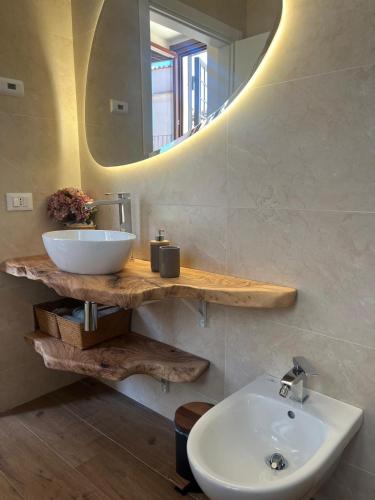 a bathroom with a white sink and a mirror at Cavour Apartment in LʼAquila
