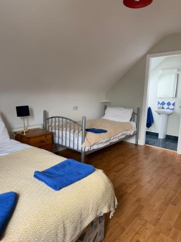 a bedroom with two beds with blue towels on them at Sailing's Island Rooms in Inisheer