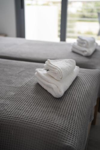 two white towels sitting on top of a bed at Ocean Breeze Residence in Kámpos