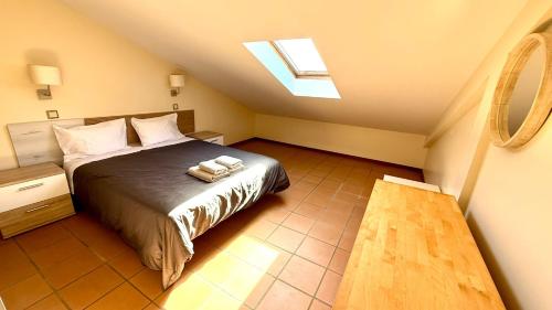 a bedroom with a bed and a skylight at Casa Sol e Praia in Porto Santo