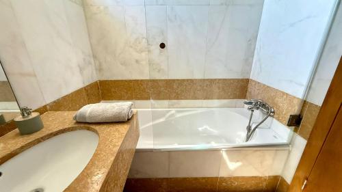 a bathroom with a bath tub and a sink at Casa Sol e Praia in Porto Santo