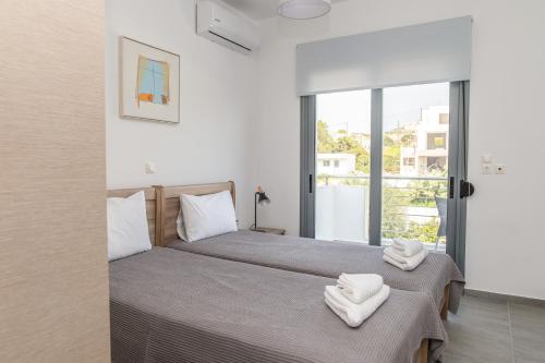 a bedroom with two beds with towels on them at Ocean Breeze Residence in Kámpos