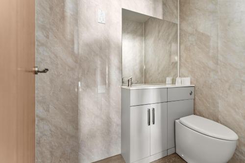 a bathroom with a toilet and a sink and a mirror at Dovedale Hotel and Restaurant in Cleethorpes