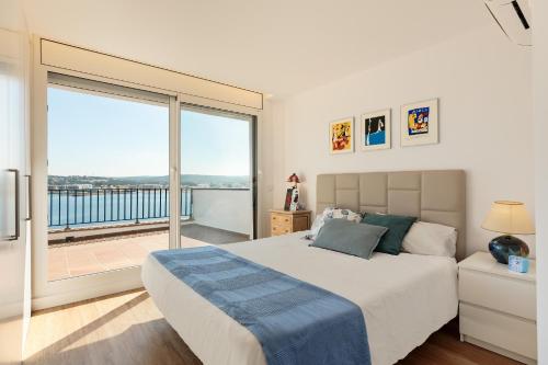 a bedroom with a large bed and a large window at La Escala- Costa Brava pool duplex apartment in L'Escala