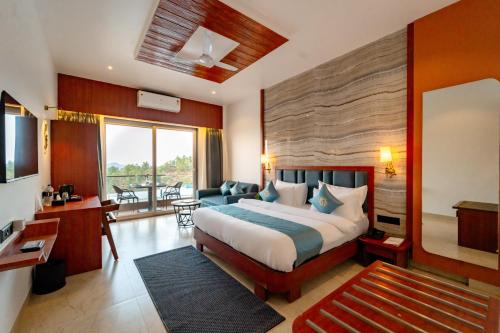 a bedroom with a large bed and a living room at Ritz Valley Resort in Mahabaleshwar
