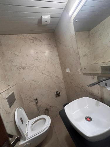 a bathroom with a white toilet and a sink at Laddu Resort in Bhīm Tāl