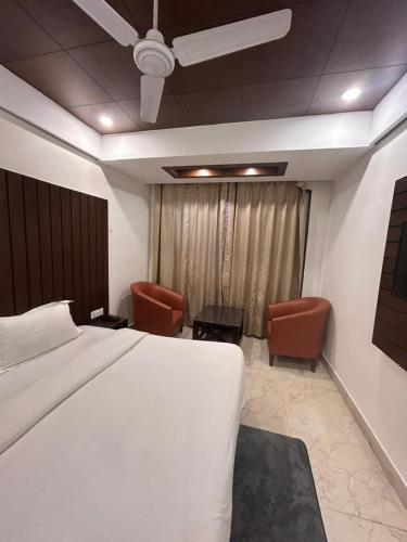 a hotel room with a bed and two chairs at Laddu Resort in Bhīm Tāl