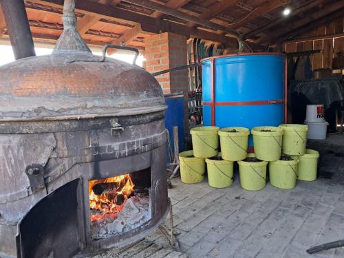 an old brick oven with a row of yellow barrels at Ramaća House in Ramaća