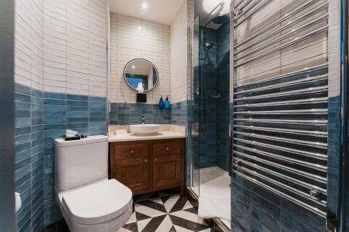 a bathroom with a toilet and a sink and a shower at The Crown & Greyhound by Innkeeper's Collection in London