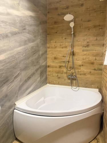 a bathroom with a white tub and a toilet at INFINITY Hotel&Spa in Almaty