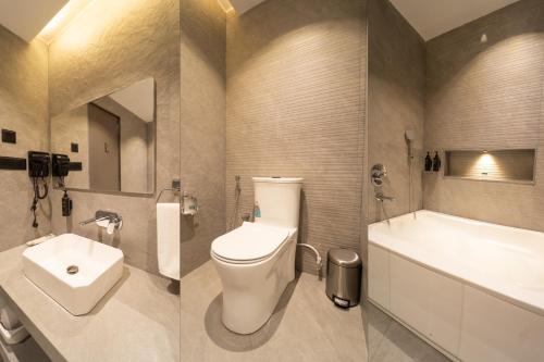 a bathroom with a toilet and a tub and a sink at Ritz Valley Resort in Mahabaleshwar
