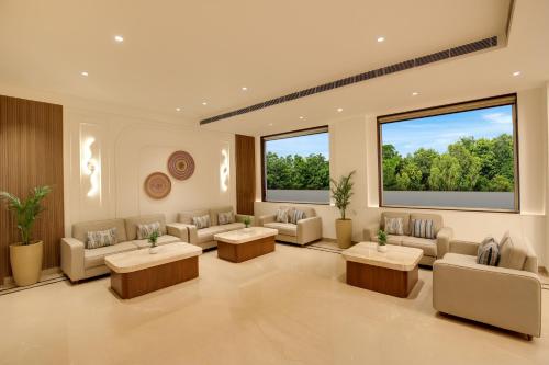 a waiting room with couches and tables and large windows at Keys Select by Lemon Tree Hotels, Amritsar in Amritsar