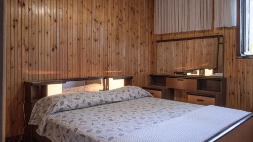 a bedroom with a bed and a wooden wall at House Katarina by Villas Guide in Blato